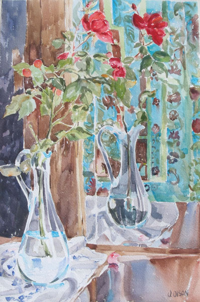 A watercolor of a clear glass blue ewer with red roses reflecting in mirror. The almost half filled ewer is sitting on top of a white tablecloth and there is a blue background since there is a blue patterned curtain reflecting in the mirror too.